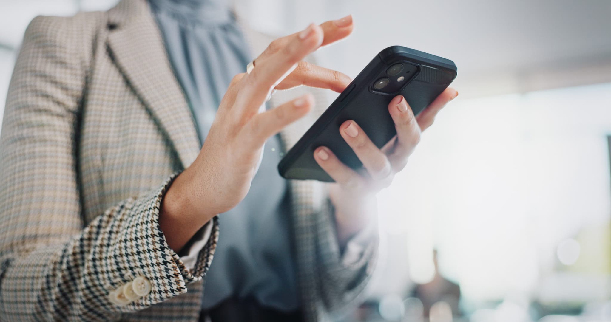 Business woman, hands and typing with phone for research, online browsing or reading news at office. Closeup of female person or employee scrolling on mobile smartphone for chatting, texting or app.